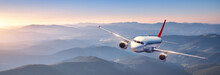 Plane Is Flying In Colorful Sky At Sunset. Landscape With Passenger Airplane Over Mountains Ranges And Hills In Fog, Orange Sky. Aircraft Is Landing. Business. Aerial View. Transport. Private Jetlane