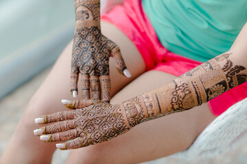 Artist applying henna tattoo on women hands. Mehndi is traditional Indian decorative art.