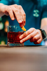 Wall Mural - man bartender hand making negroni cocktail in bar