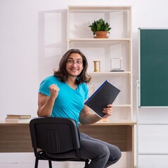 Wall Mural - Young male student in front of green board