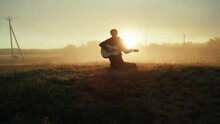 Artistic Man Singing Song Playing Acoustic Guitar Outdoor At Cinematic Misty Fog Sunset Sunrise Countryside Field. Charismatic Art Male Play Musical Instrument Live Performance Melody Musician Star 4k