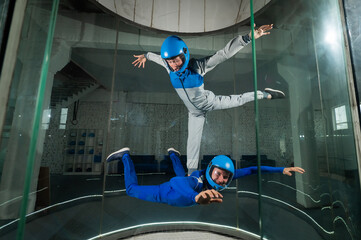 Wall Mural - A man and a woman enjoy flying together in a wind tunnel. Free fall simulator