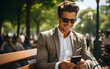 © kitti - Businessman using smartphone while waiting at park