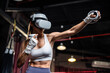 © Kawee - Asian sportswoman using innovative technology VR glasses for exercise.