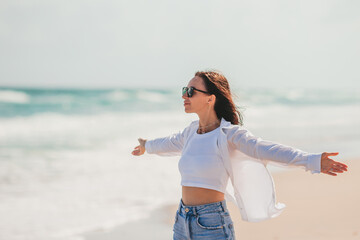 Wall Mural - Young happy woman on the beach enjoy her summer vacation. Girl is happy and calm in her stay on the beach