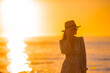 © travnikovstudio - Young happy woman on the beach enjoy her summer vacation at sunset