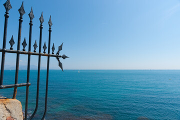 Wall Mural - Wrought iron decorative barrier on edge Mediterranean sea landscape to horizon at Antibes