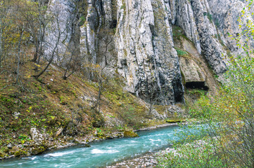 Gray rocks in the mountains. Mountain landscape. Layers of rock . A mountain river with clear and transparent water. Landscape with a view of gray stones in a mountain river.