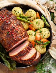 Wall Mural - Roasted sliced Christmas ham on plate with vegetables, festive decoration.