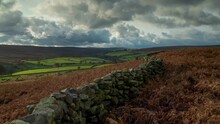 A Timelapse Of Commondale In The North York Moors National Park, England In Autumn With Dramatic Clouds, Bracken And Stone Wall Line.