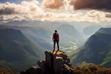 Fototapeta  - Wanderer steht auf einem Felsen an der Bergspitze und schaut über ein Gebirge mit toller Landscahft 