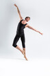 Ballet Dancer Young Athletic Man in Black Suit Posing in Ballanced Stretching Dance Pose Studio On White.