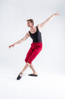 © danmorgan12 - Portrait of Concentrated Contemporary Ballet Dancer Flexible Athletic Man Posing in Red Tights in Ballanced Dance Pose With Hands In Line on White.