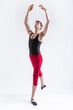 © danmorgan12 - Stretching of Concentrated Contemporary Ballet Dancer Flexible Athletic Man Posing in Red Tights in Ballanced Dance Pose With Hands Lifted on White.
