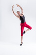 © danmorgan12 - Portrait of Tranquil Contemporary Ballet of Flexible Athletic Man Posing in Red Tights in Ballanced Dance Pose With Hands Lifted in Studio on White.