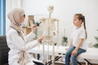 © sofiko14 - Physician showing ribs on anatomical model to preteen girl