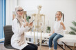 © sofiko14 - Female GP and tween girl posing near skeleton in exam room