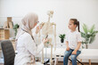 © sofiko14 - GP consulting tween kid about human body by anatomical model