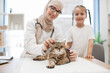 © sofiko14 - Woman in hijab and child posing near furry pet on vet visit