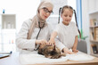 © sofiko14 - Doctor listening to pet's lungs with stethoscope near child