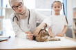 © sofiko14 - Muslim vet vaccinating cat near little girl in office