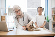 © sofiko14 - Vet with syringe and tween girl posing near cat on table