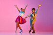 © master1305 - Emotional and stylish children, boy and girl in retro clothes dancing lindy hop against pink studio background in neon light. Concept of childhood, hobby, active lifestyle, performance, art, fashion