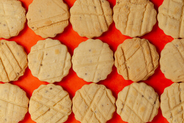 Wall Mural - Closeup of a group of assorted carom seeds cookies or salted ajwain cookies. Top view wallpaper.