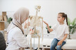 © sofiko14 - GP consulting tween kid about human body by anatomical model
