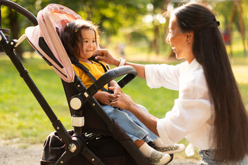 Wall Mural - Japanese Mom Bonding With Little Baby Seated In Stroller Outdoor