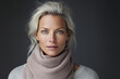 © Synthetica - Mid adult Nordic blonde woman, beautiful mature 40s lady pretty Scandinavian model with blond hair and light blue eyes wearing scarf looking at camera on dark grey background, close up face portrait.
