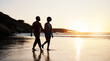 Beach, sunset and silhouette couple walking on sand, holding hands and enjoy romantic time together. Wellness, summer freedom and dark shadow of people bonding, talking and relax on tropical date