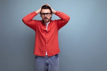 pensive young brunette man in red shirt