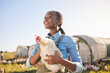 © Davids C/peopleimages.com - Farm, agriculture and black woman with chicken in field, countryside or nature for protein, growth or ecology. Agro business, sustainable farming and farmer and bird for free range poultry production