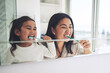 © Azee/peopleimages.com - Mother, child and brushing teeth in morning routine, dental hygiene or healthcare together by mirror in bathroom. Happy mom and daughter cleaning mouth in tooth whitening, oral or gum care at home