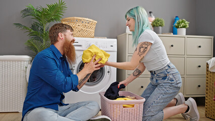 Sticker - Man and woman couple smiling confident washing clothes at laundry room