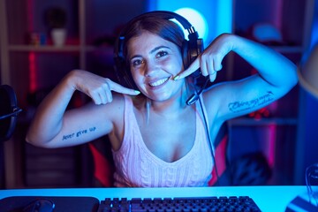 Poster - Young blonde woman playing video games wearing headphones smiling cheerful showing and pointing with fingers teeth and mouth. dental health concept.