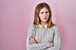 © Krakenimages.com - Beautiful woman standing over pink background skeptic and nervous, disapproving expression on face with crossed arms. negative person.