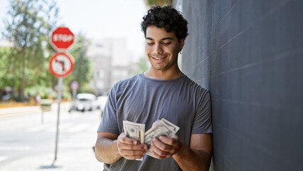 Sticker - Young latin man smiling confident counting dollars at street