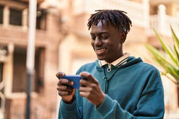 Wall Mural - African american man smiling confident watching video on smartphone at street