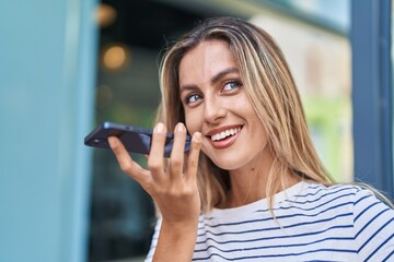 Sticker - Young blonde woman smiling confident talking on the smartphone at street