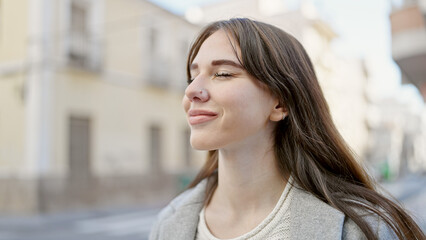 Poster - Young hispanic woman standing with closed eyes at street