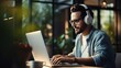 © mariiaplo - Smiling young man with headphones working on laptop