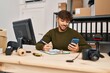 © Krakenimages.com - Young arab man ecommerce business worker writing on document using smartphone at office