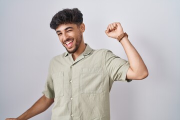 Poster - Arab man with beard standing over white background dancing happy and cheerful, smiling moving casual and confident listening to music