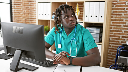 Sticker - African american man doctor using computer working at the clinic