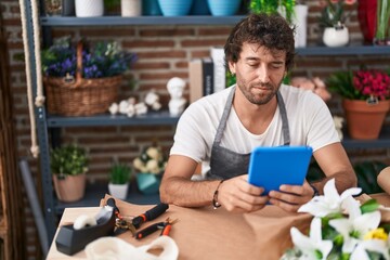 Canvas Print - Young hispanic man florist using touchpad at flower shop