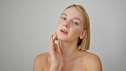 Poster - Young blonde woman touching face over isolated white background