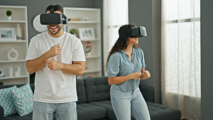 Canvas Print - Man and woman couple dancing using virtual reality glasses at home