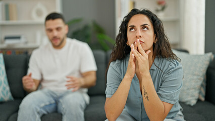 Sticker - Man and woman couple sitting on sofa arguing stressed at home